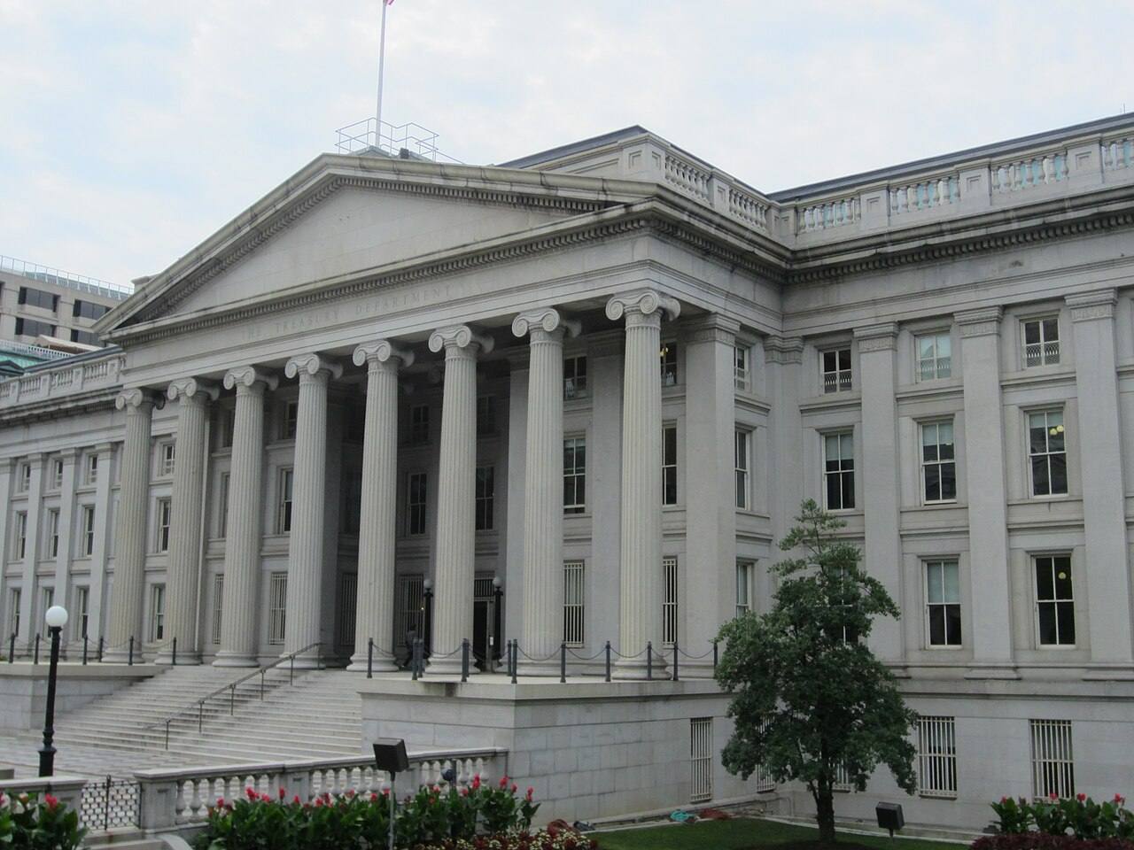 Fachada principal del edificio del Departamento del Tesoro de EE. UU. en Washington D.C., con columnas jónicas y el rótulo "THE TREASURY DEPARTMENT" tallado en el friso